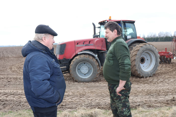 Галоўны аграном гаспадаркі Віктар Драчылоўскі з механізатарам Сяргеем Кубліцкім абмяркоўваюць ход сяўбы зернебабовых